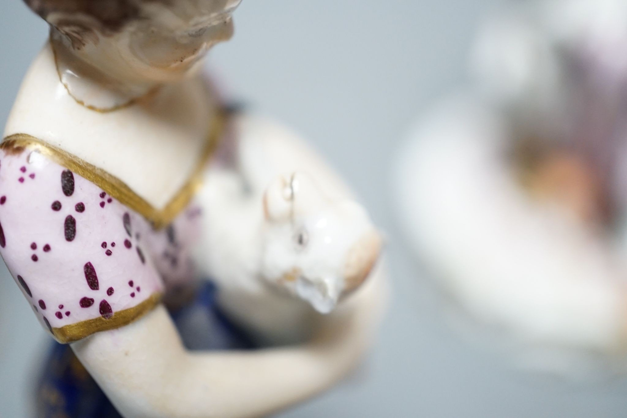 A Minton porcelain figure of a lady seated with a dog c.1830, a pair of Derby figures of a girl and a boy with a dog and a sheep, and a Bloor Derby vase